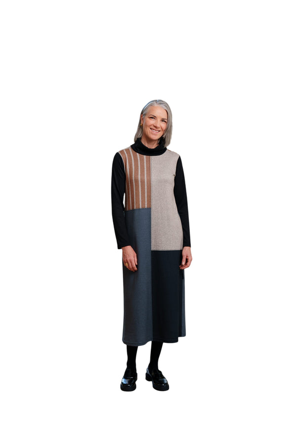 Femme souriante portant la robe 7/8 La Maison du Bleuet noire et rayée à col roulé et découpes asymétriques