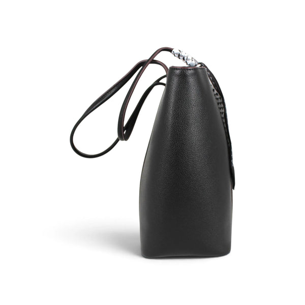 Vue latérale du sac fourre-tout noir Maison Taïga en cuir grainé avec anses fines et détails tressés