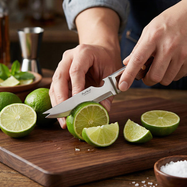 Couteau de bar Final Touch tranchant une lime sur une planche en bois.