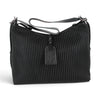 Sac à main épaule Maison Taïga en cuir noir avec texture tressée, doté d'une sangle ajustable et d'une étiquette.
